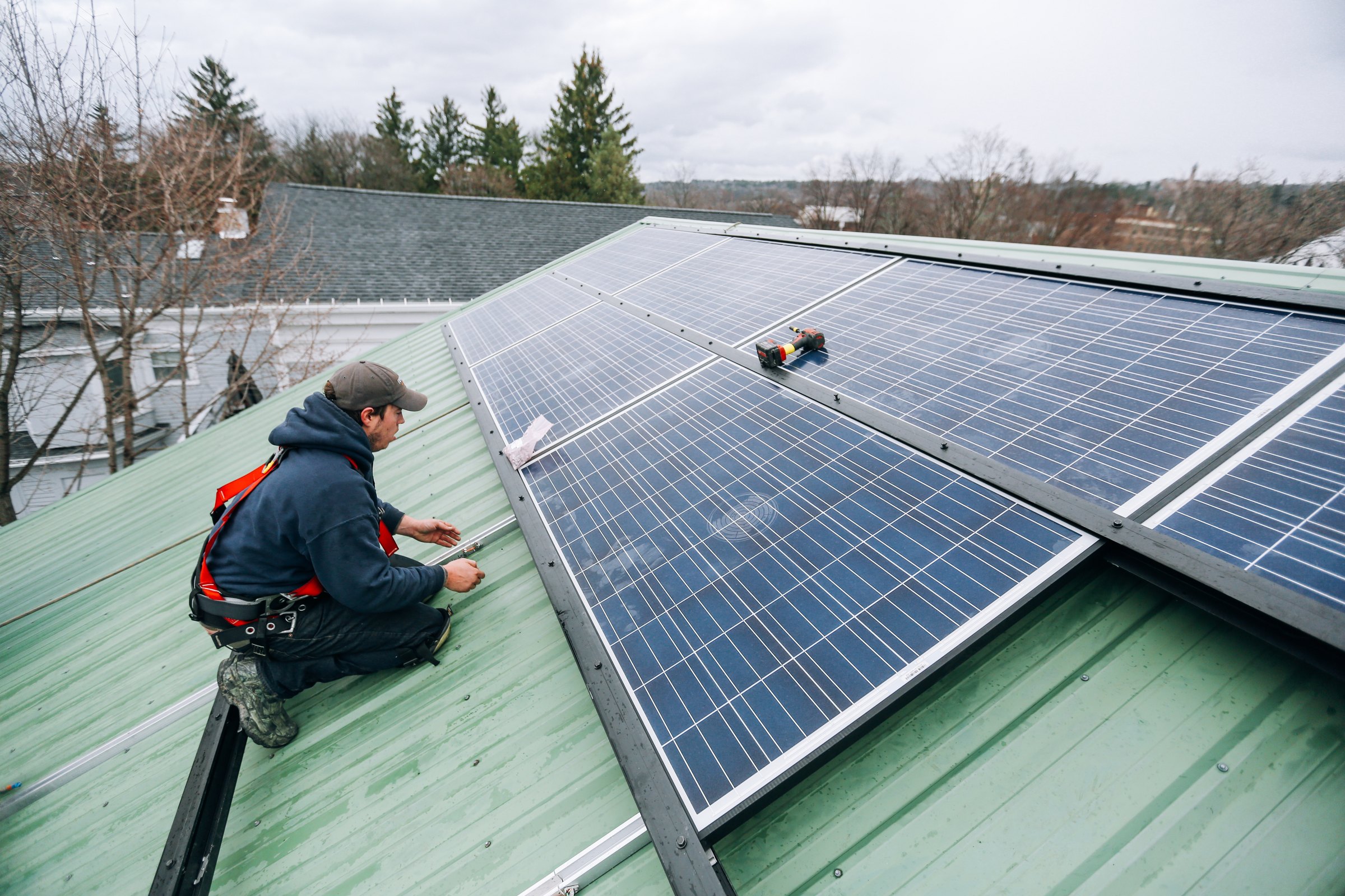 Solar technicians securing panels on a residential roof